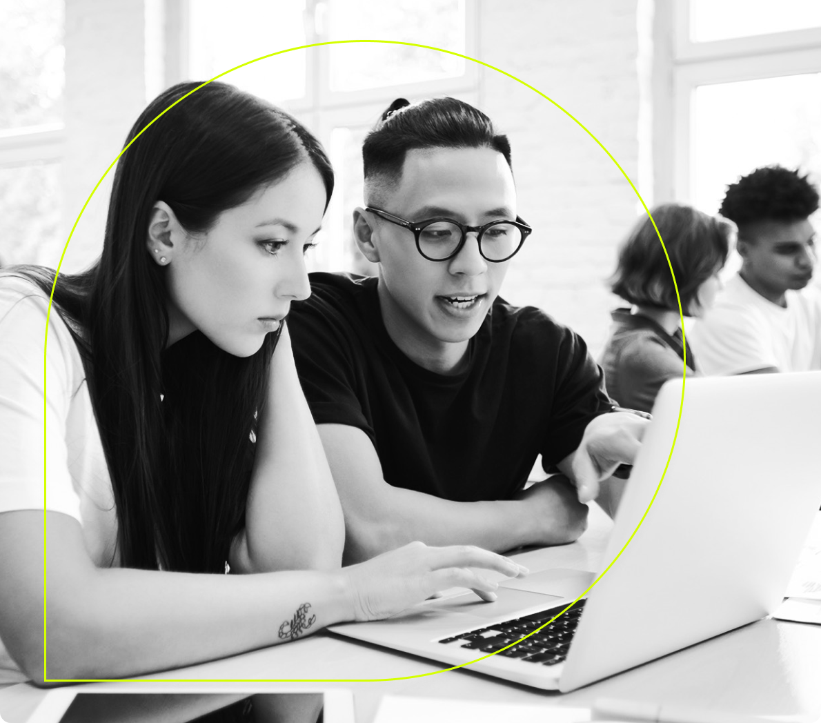 Two people collaborate while working on a laptop